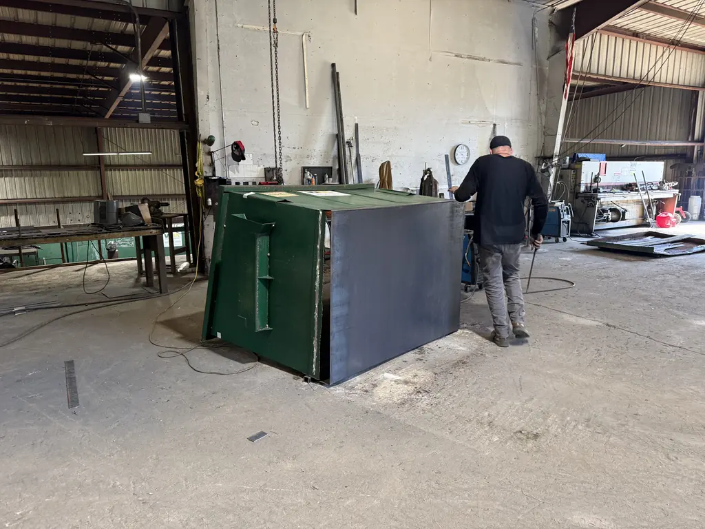 After: front-load dumpster with a new steel floor plate installed, ready for repaint at the NFC shop in Ocala