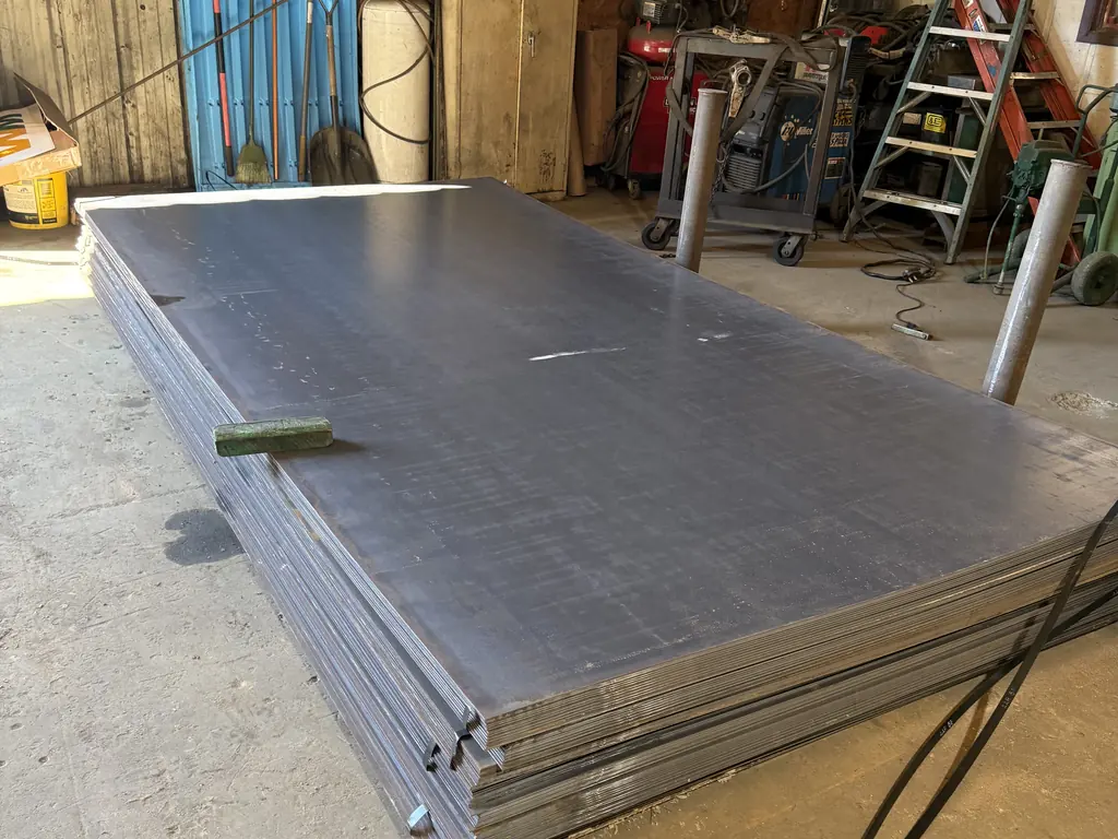 Stack of new steel plate stock in the Ocala shop used for dumpster and roll-off container floor repair