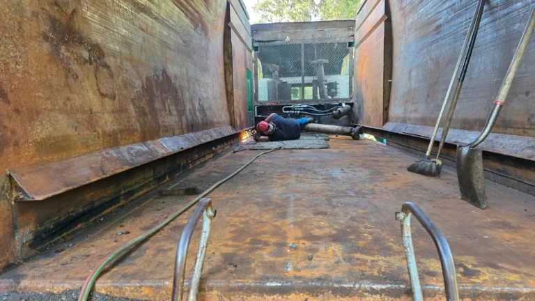 Welding structural repair inside a roll-off container at NFC shop in Ocala
